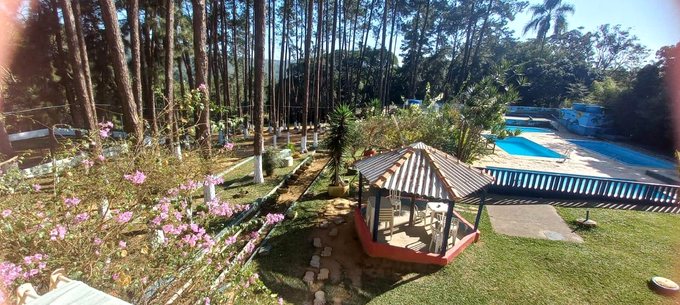 Área arborizada com quiosque e piscinas da unidade em Suzano